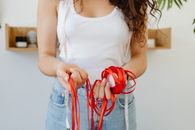 Woman in White Tank Top Holding Red and White Candy Cane
