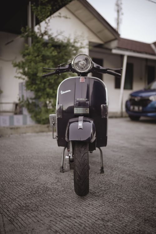 Free A classic Vespa scooter parked outdoors, showcasing its iconic design. Stock Photo