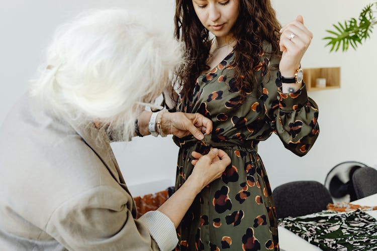 Gray Haired Woman Sewing The Woman's Dress 