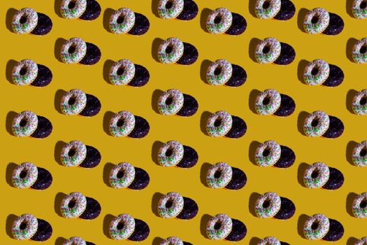 A vibrant arrangement of chocolate and sprinkle donuts on a bright yellow surface.
