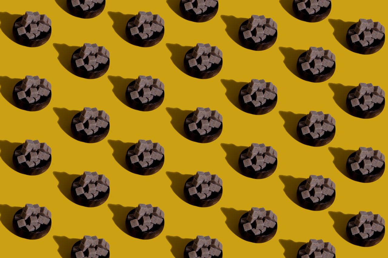 abstract display of brown sugar cube piles on yellow background formin