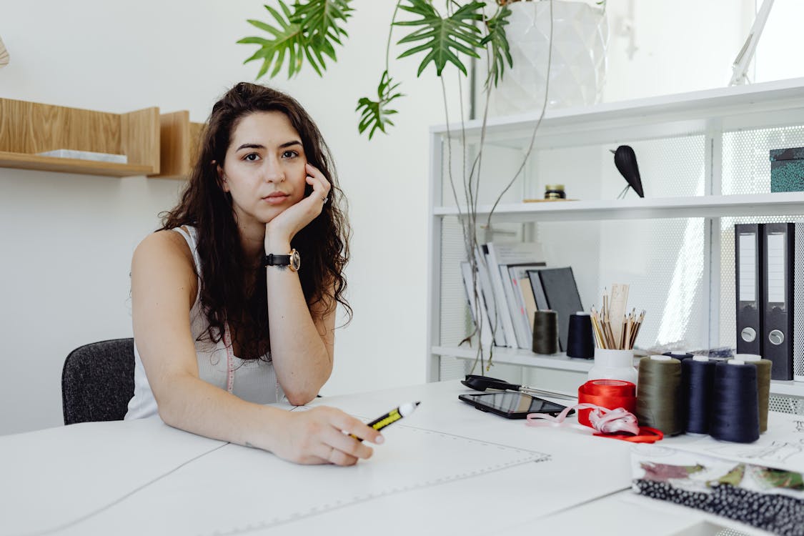 Free A Woman Sitting in Her Office Stock Photo