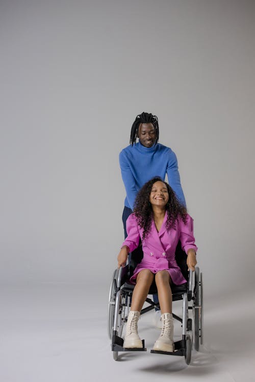 Man Standing Behind a Woman on a Wheelchair