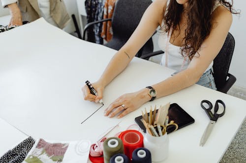 A Woman Writing on a Blank Paper with a Marker