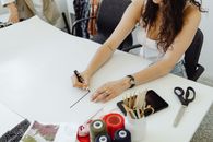 Woman in White Sleeveless Top Writing on White Paper