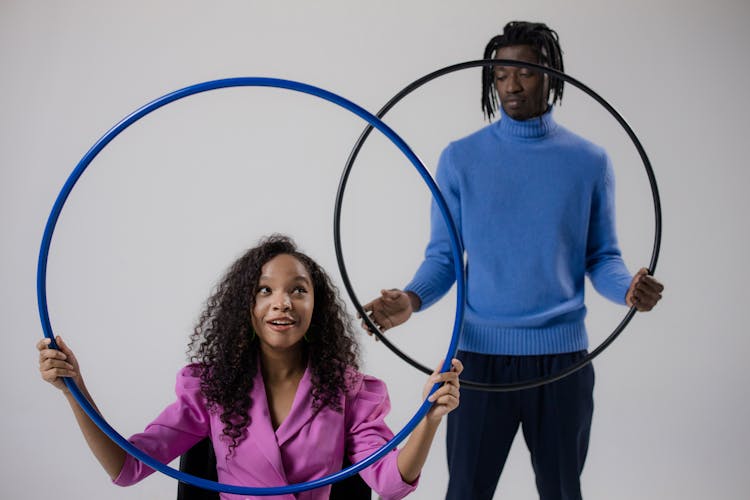 A Man And A Girl Holding Hula Hoops