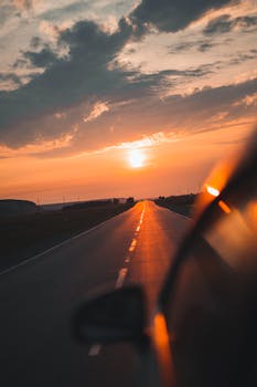 Road trip adventure with a majestic sunset view from a car on an open highway. Serene travel scene.