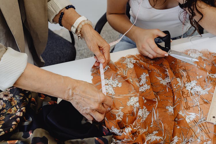 Hands Measuring The Floral Fabric