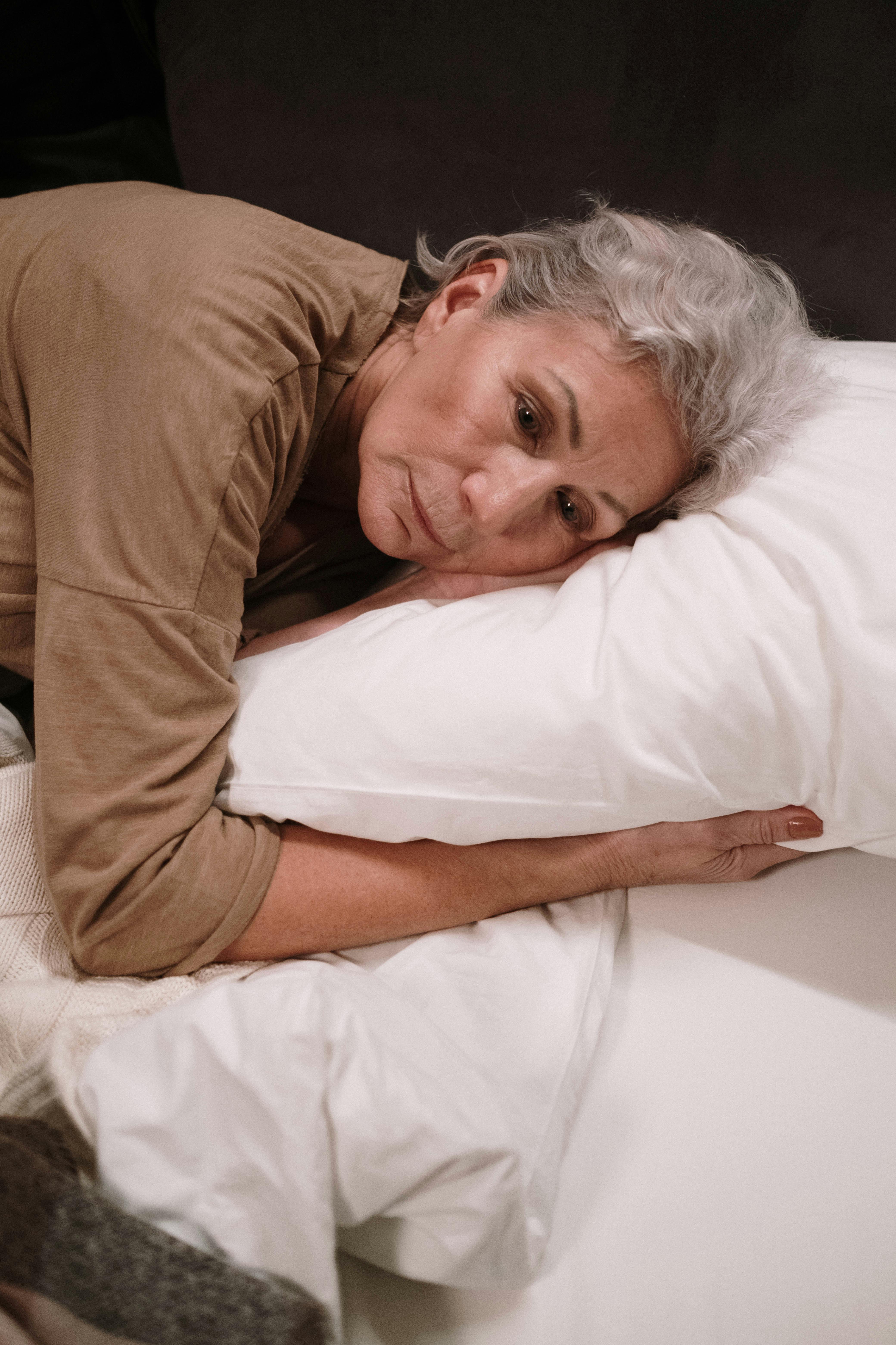 an elderly woman lying on the bed