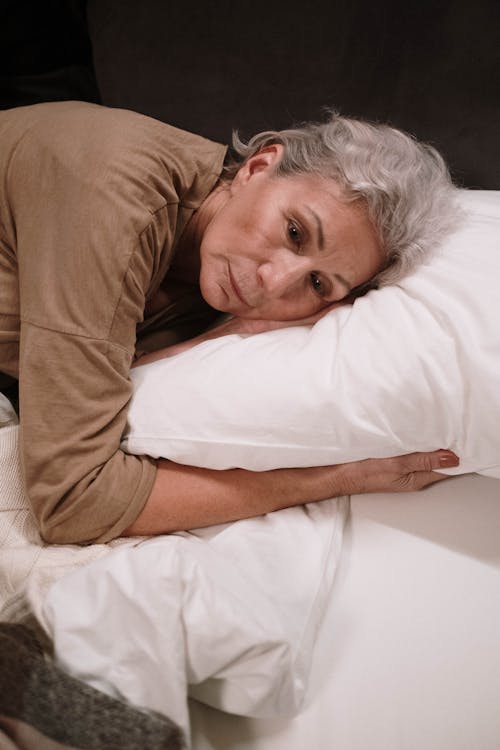 Free An Elderly Woman Lying on the Bed Stock Photo