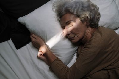 Une femme âgée dort paisiblement dans un lit confortable