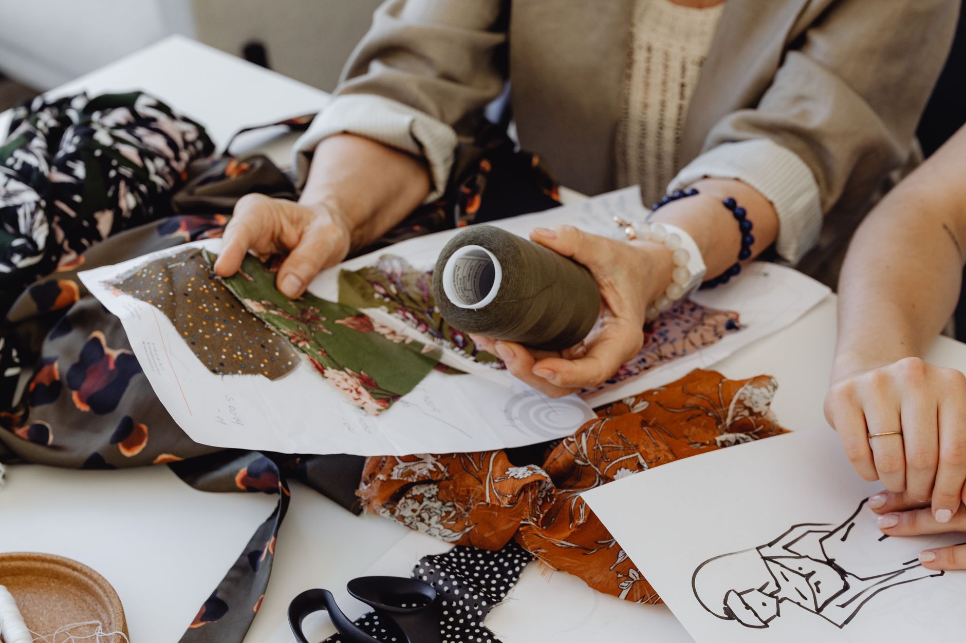 Hands Holding Floral Fabric and Thread