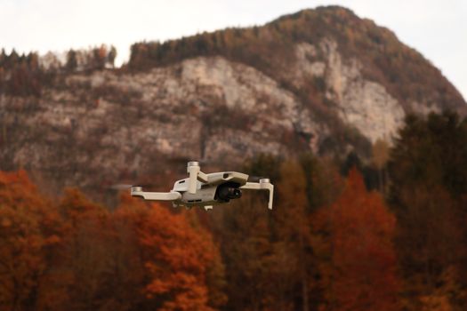 Drone flying near a majestic mountain with autumn foliage.