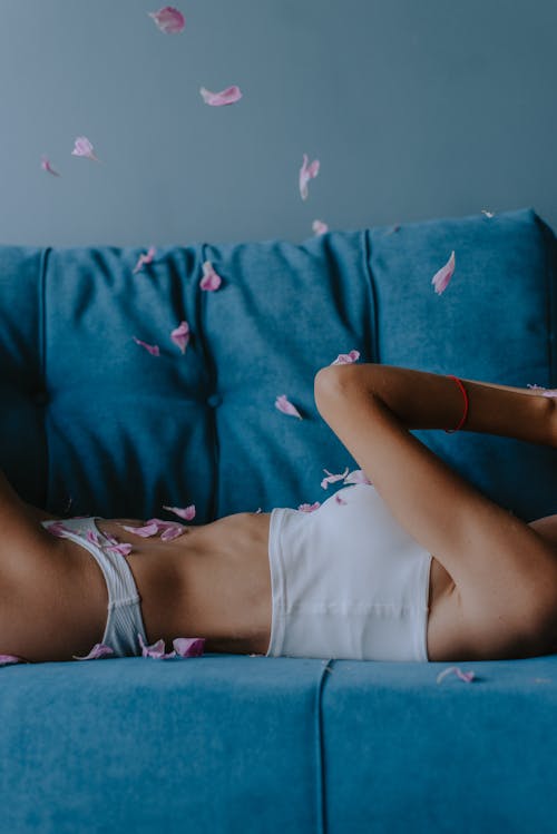 Woman Wearing a White Pantie and Tank Top Lying on Sofa