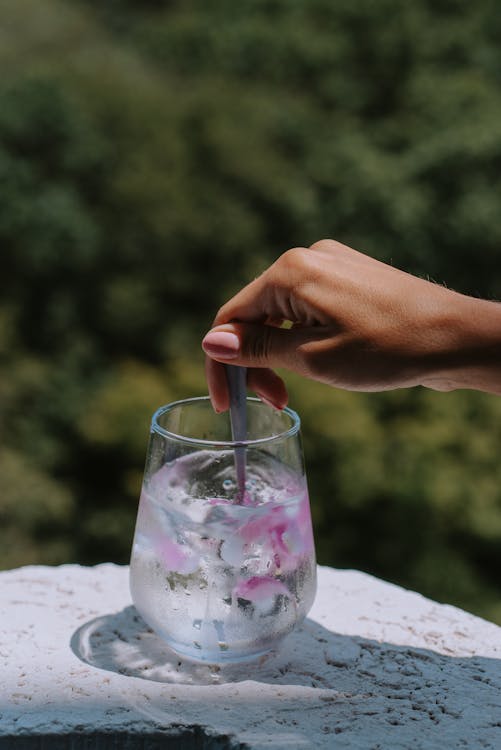 Free Close-Up Shot of a Person Stirring a Glass of Water Stock Photo