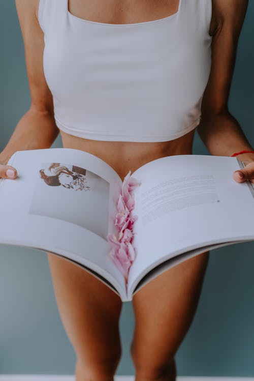 Woman Holding an Open Book with Petals