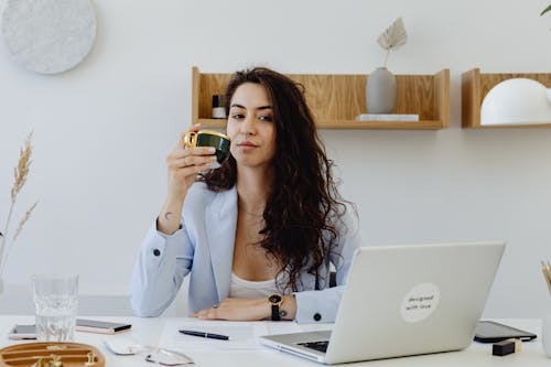 A Beautiful Woman Sitting while Holding a Cup of Coffee