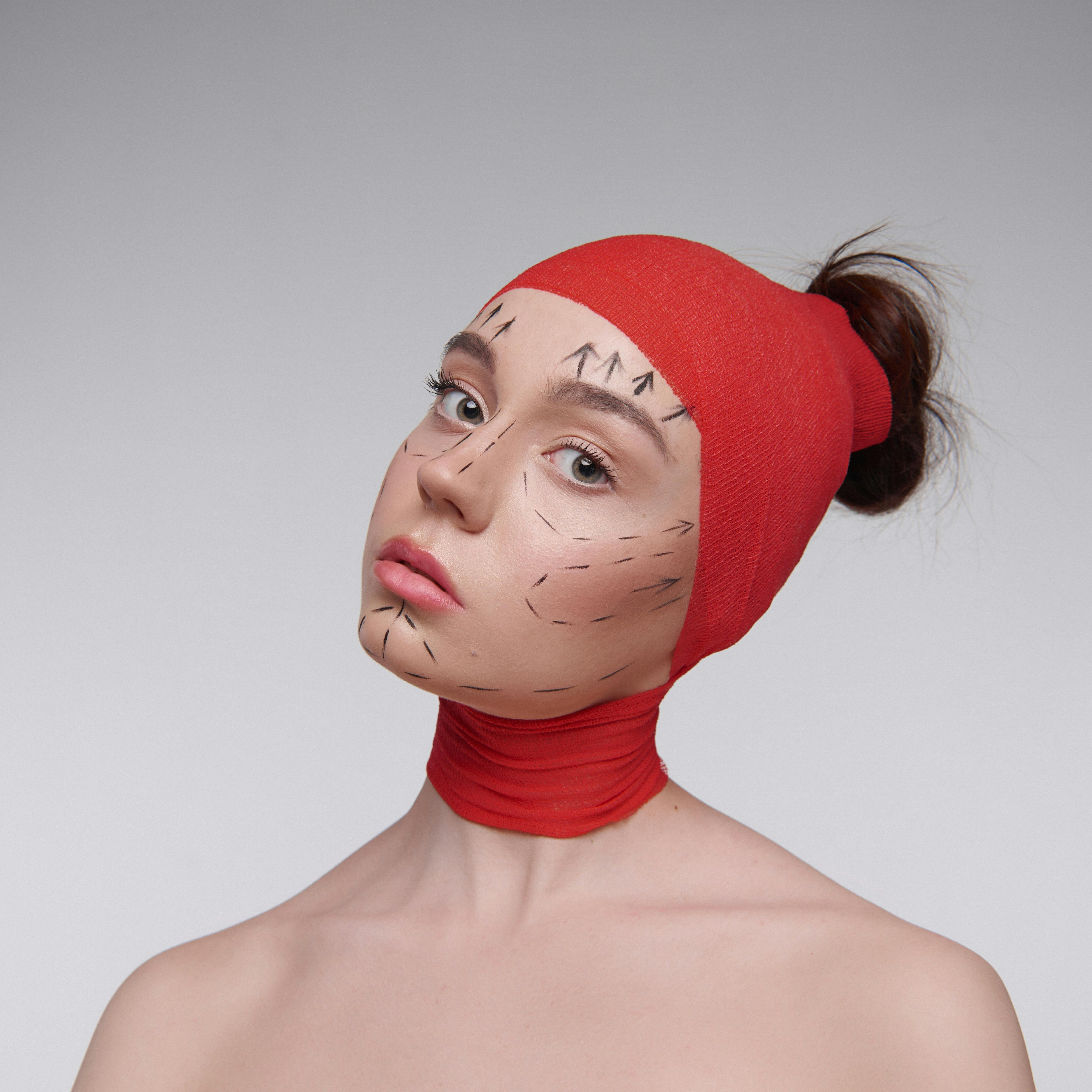 Woman in Red Knit Cap with Drawing on Her Face