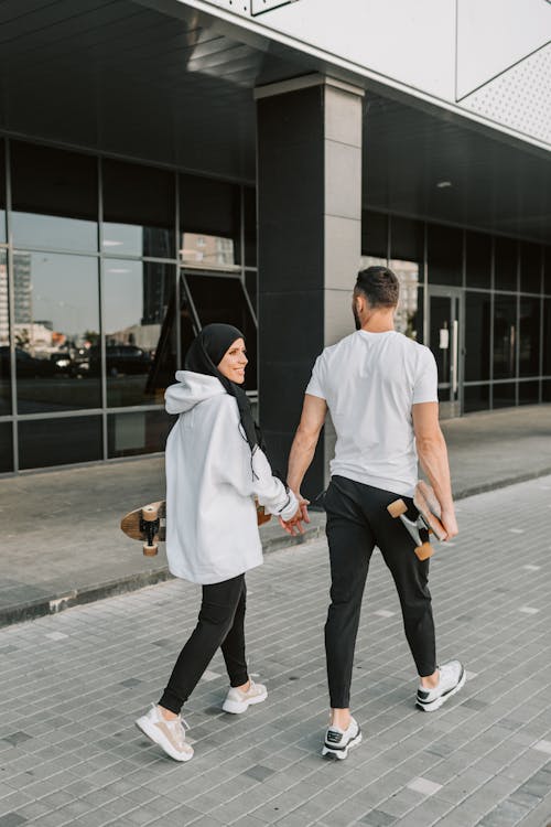 Free Couple Holding Hands while Walking Stock Photo