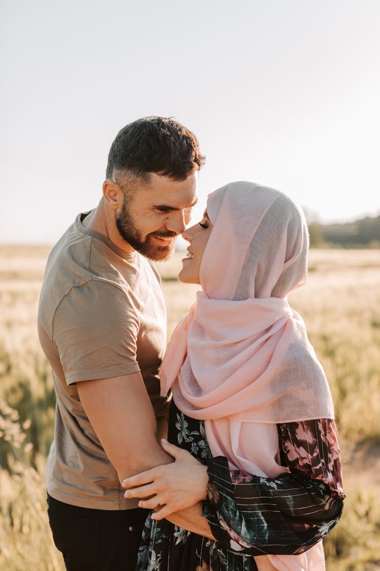 A Couple Smiling While Looking At Each Other