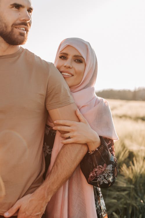 Free Woman in Pink Hijab Standing beside Man in Brown Shirt Stock Photo