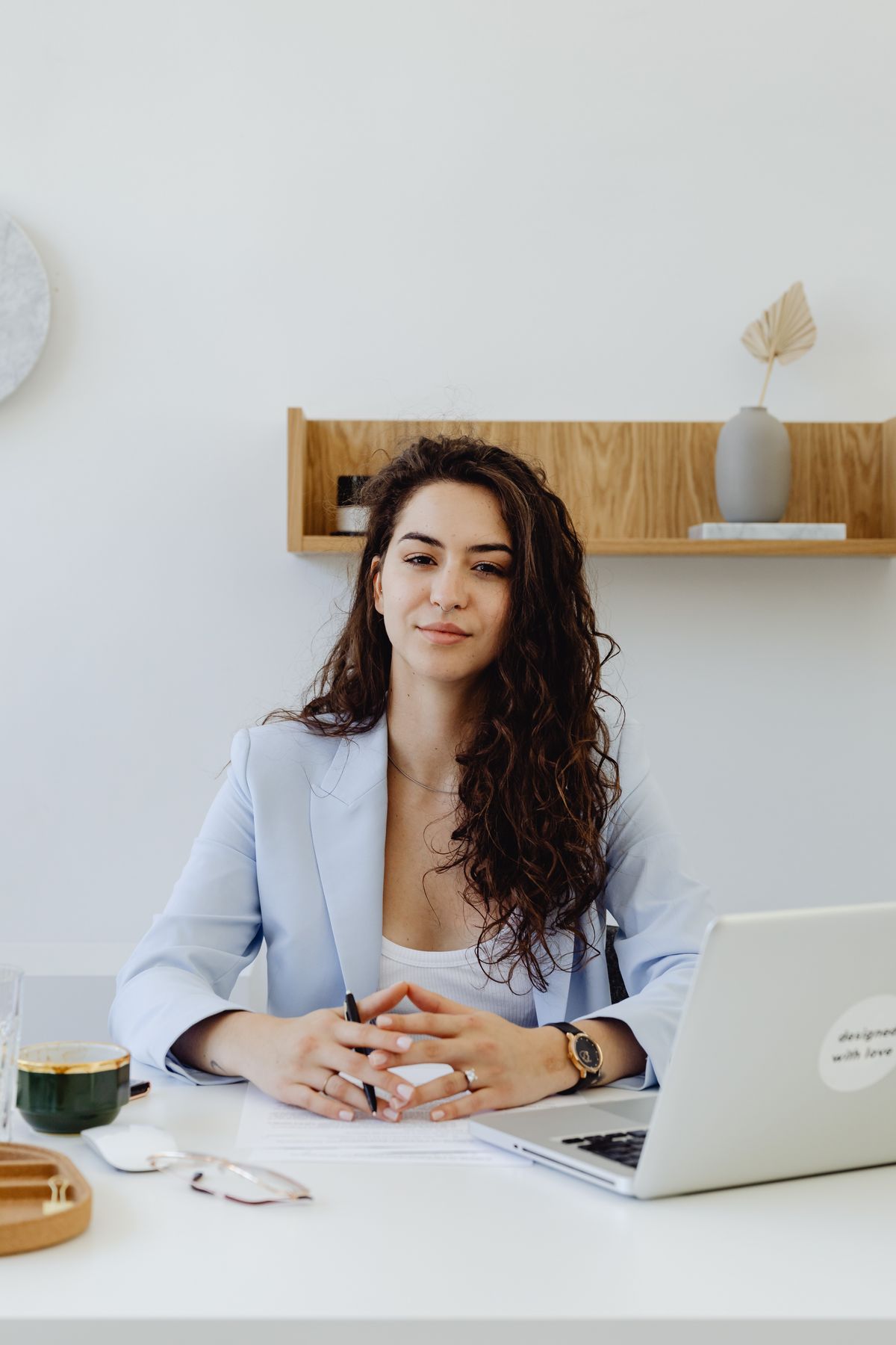 Portrait of a female founder sitting confidently at a desk in a modern office