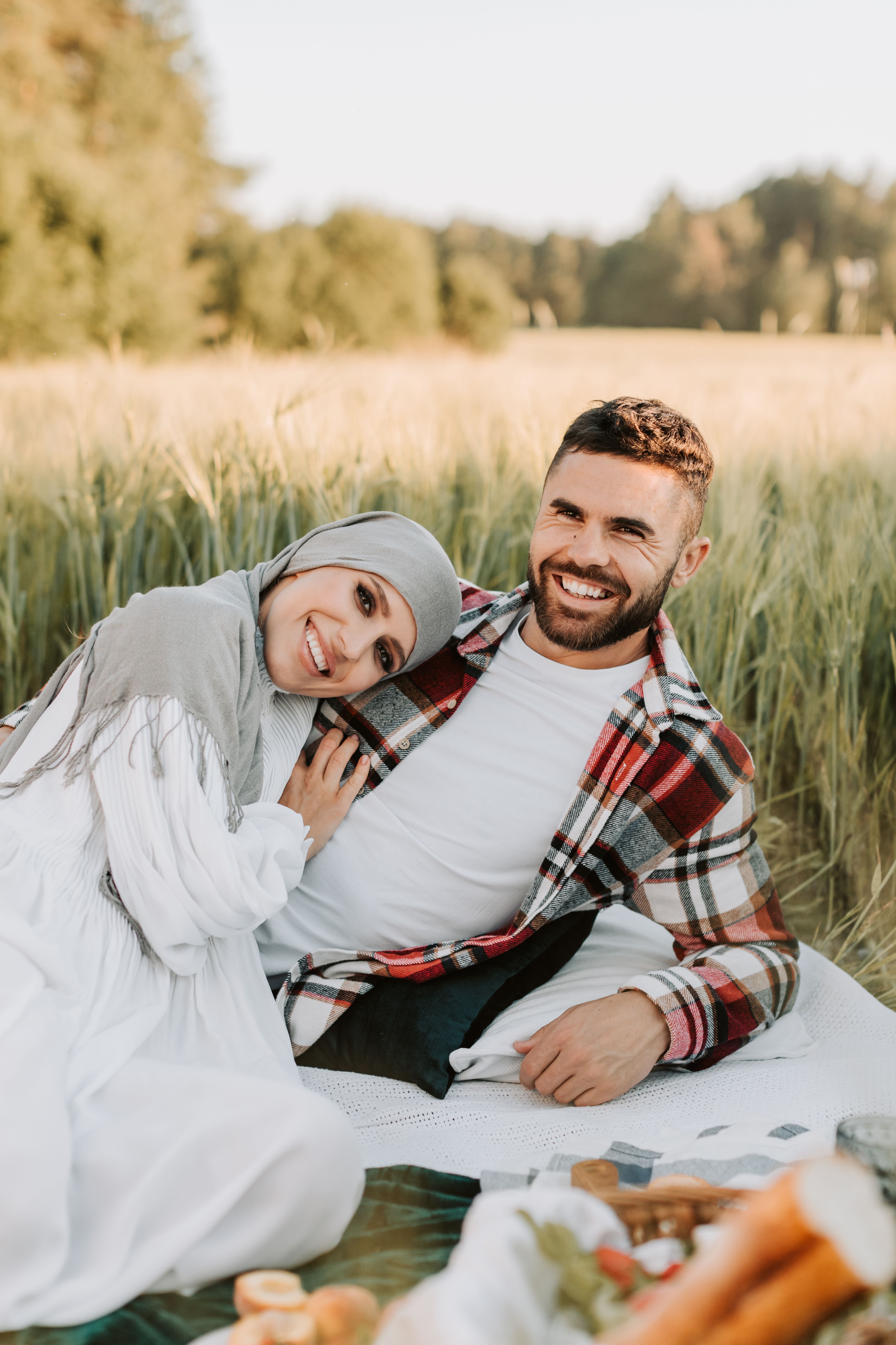 Happy couple embracing in a sunny wheat field