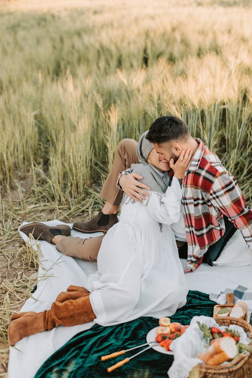 Man and Woman Sitting on Blue Textile