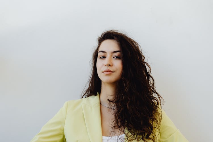 A Woman With Long Hair  Wearing A Yellow Blazer 