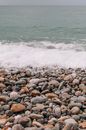 Sea Foam Reaching the Shore on a Pebble Beach