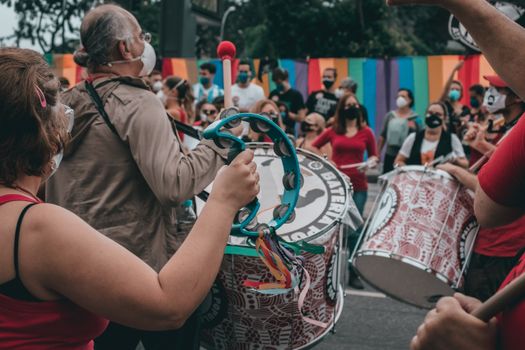 A colorful protest in Rio de Janeiro, featuring diverse people playing drums and tambourines in the street. — photo by michelle guimarães