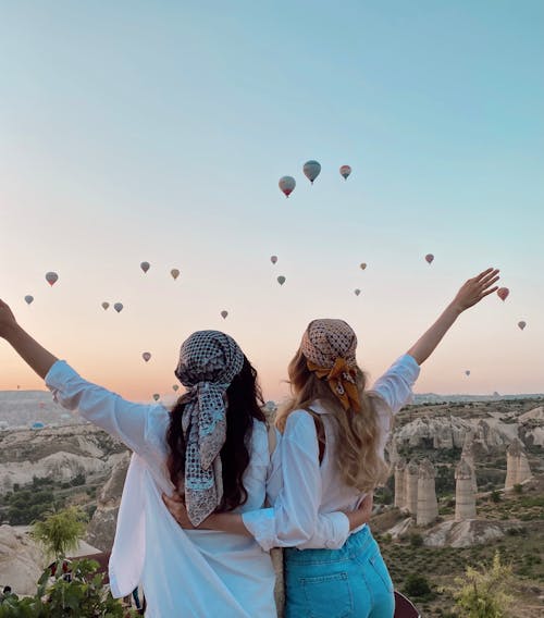 Free Two Women Wearing Headscarf Watching Hot Air Balloons in the Sky Stock Photo