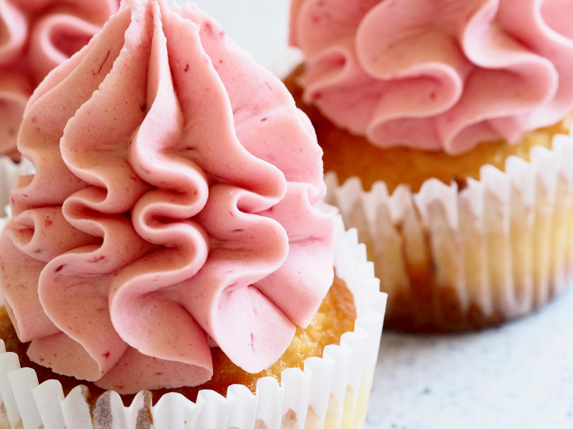 vanilla cupcakes with strawberries and cream frosting