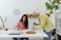 Woman in Pink Long Sleeve Shirt Holding Black Pen