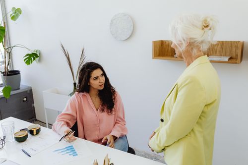 Free Two women engaging in a business discussion in a modern office setting. Stock Photo