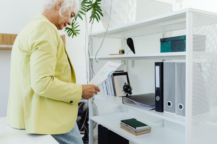 Elderly Woman Reading Documents In An Office 