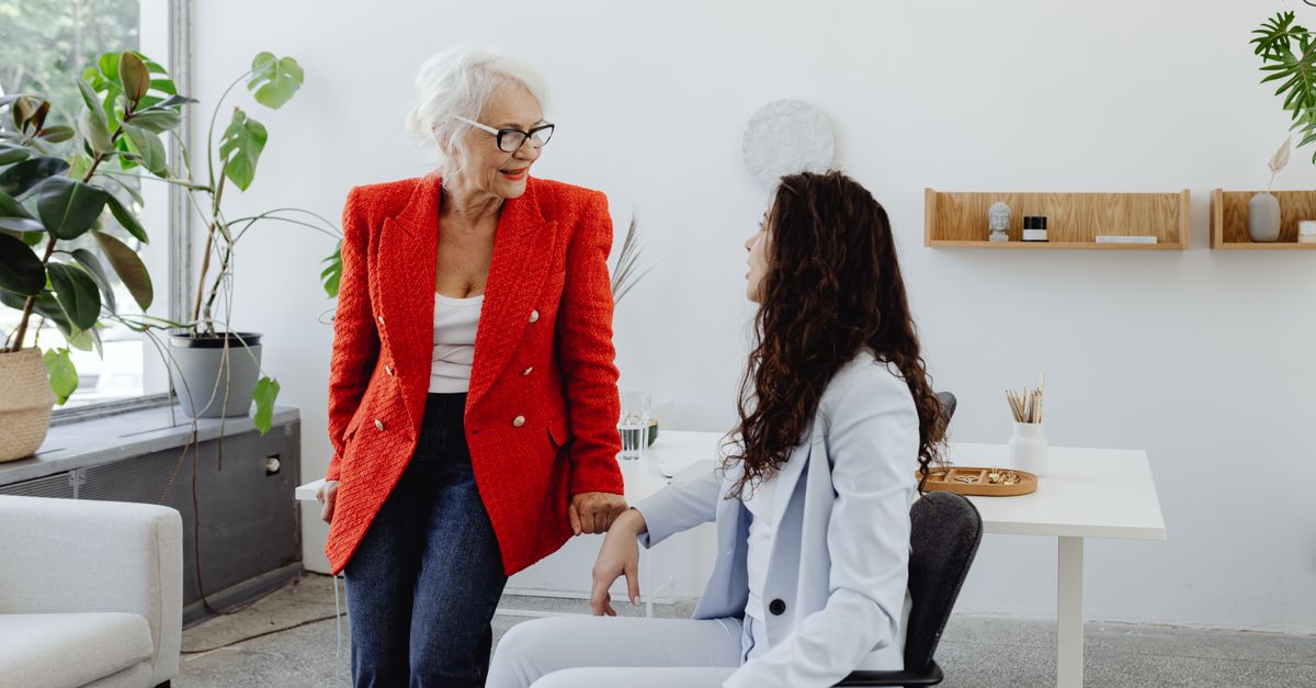 Duas mulheres de negócios em conversa em um espaço de escritório elegante com plantas e decoração minimalista.