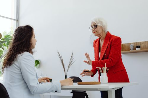 Free Two women engage in a professional discussion in a modern office setting. Stock Photo