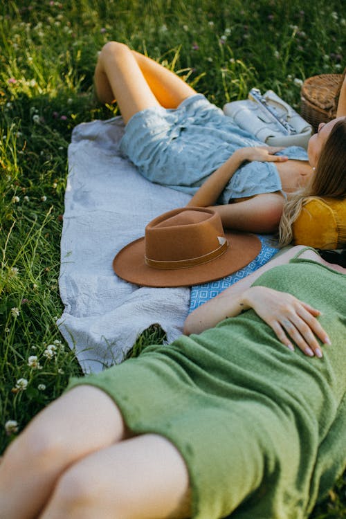 Free Women Relaxing by Lying Down over the Picnic Blankets Stock Photo