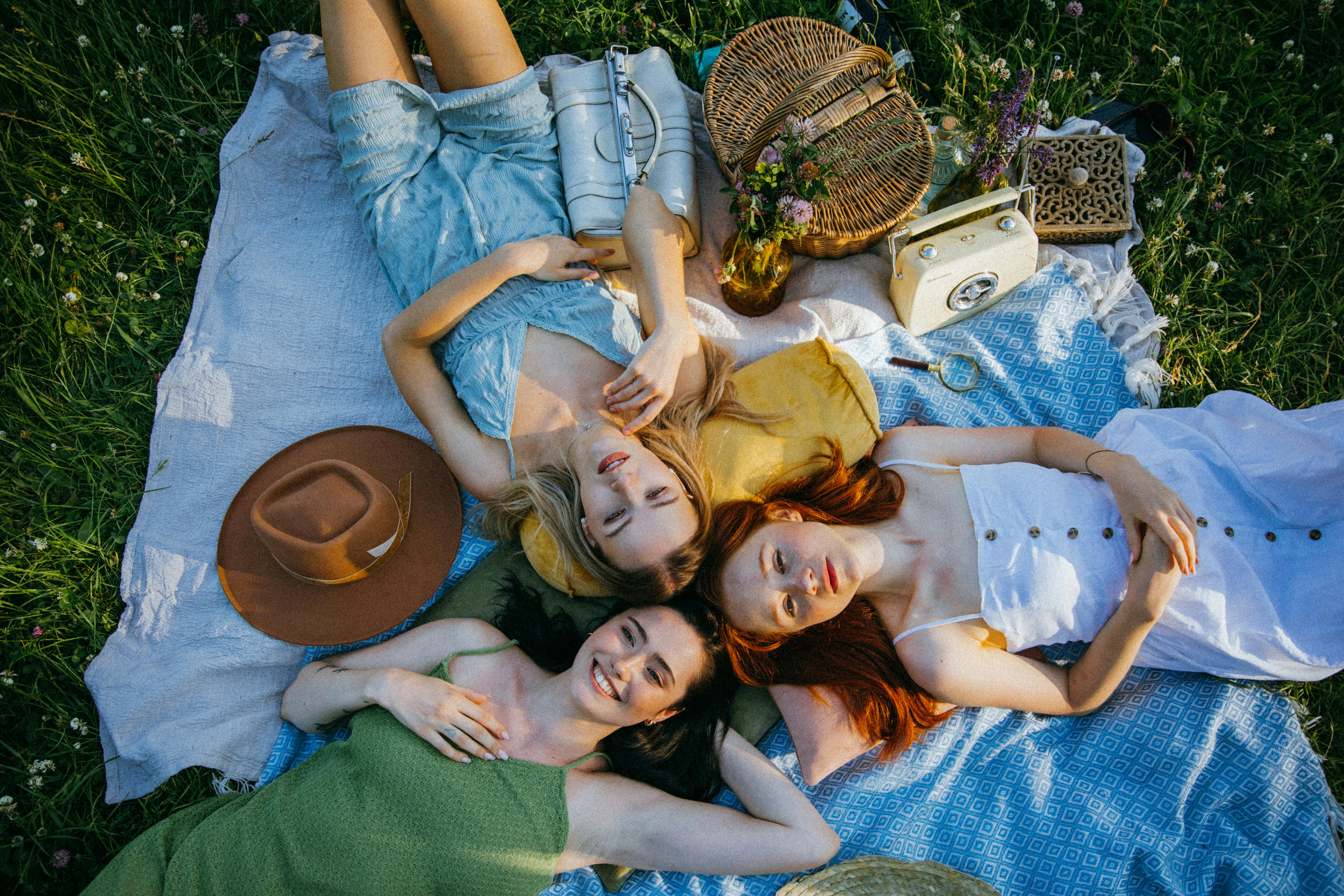 a group of friends lying on a picnic blanket