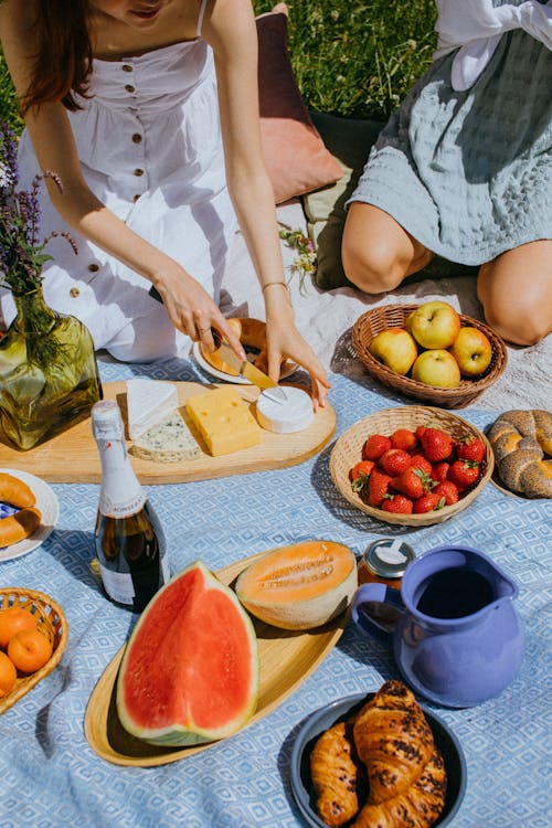 

A Woman Slicing Cheese during a Picnic