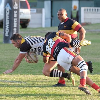 Rugby players tackling on a green field during a match in South Africa, showing athleticism and teamwork.（イメージ）