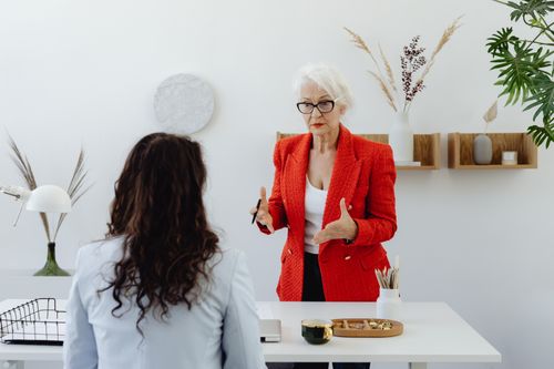 Free Two women having a focused discussion in a modern office environment. Stock Photo