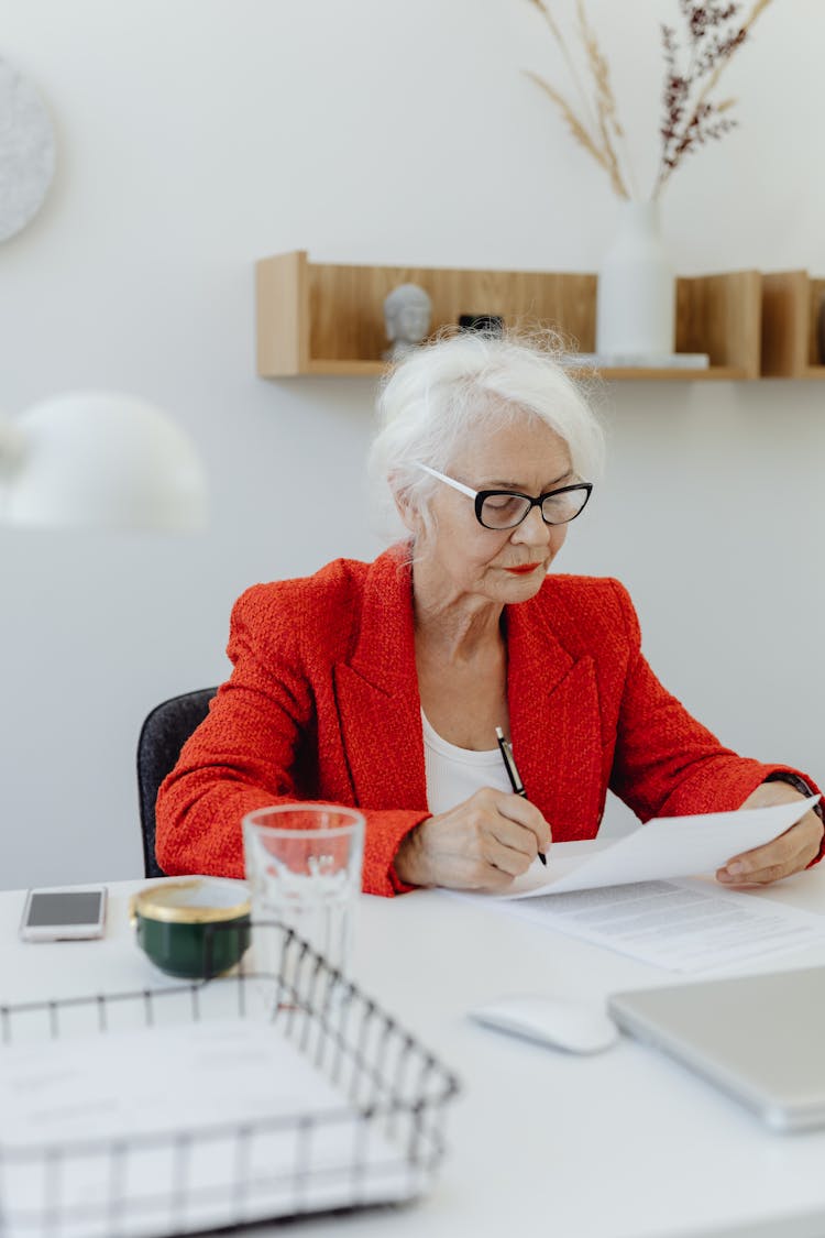 An Elderly Woman Working Inside An Office