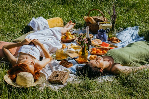 Women Lying on Green Grass Field