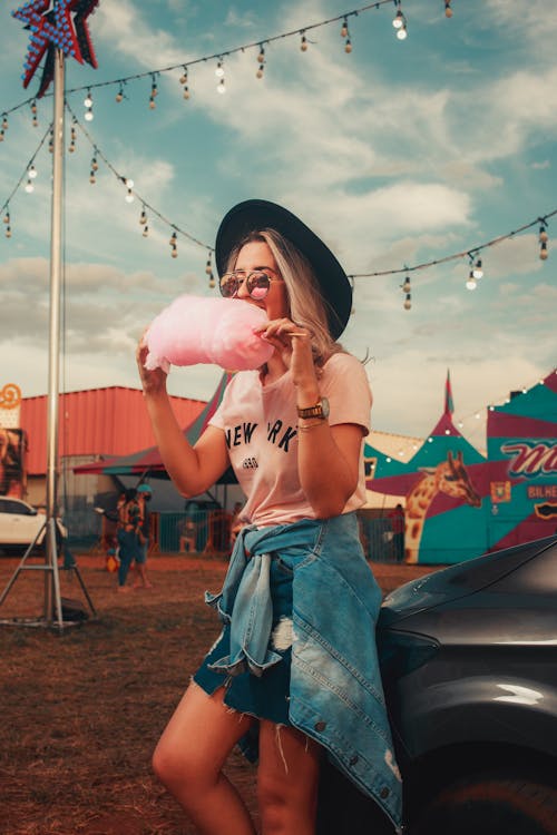Woman Eating Cotton Candy at Fair