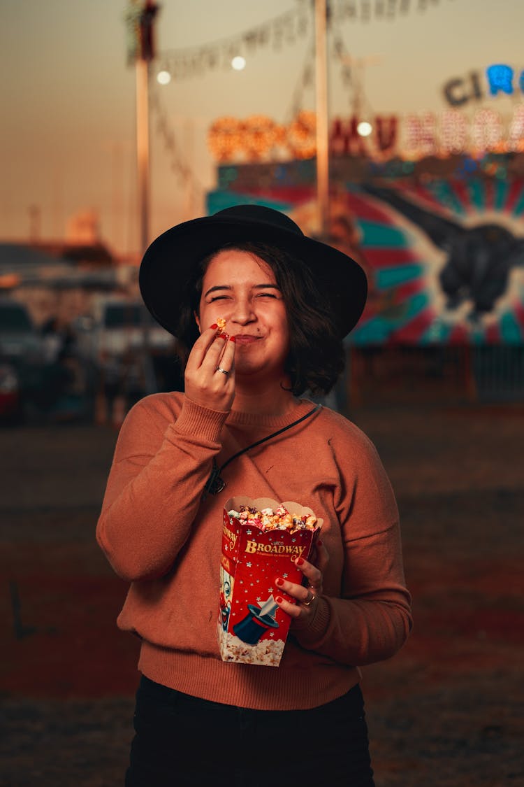 Retro Style Portrait Of A Woman Eating Popcorn And Circus In Background