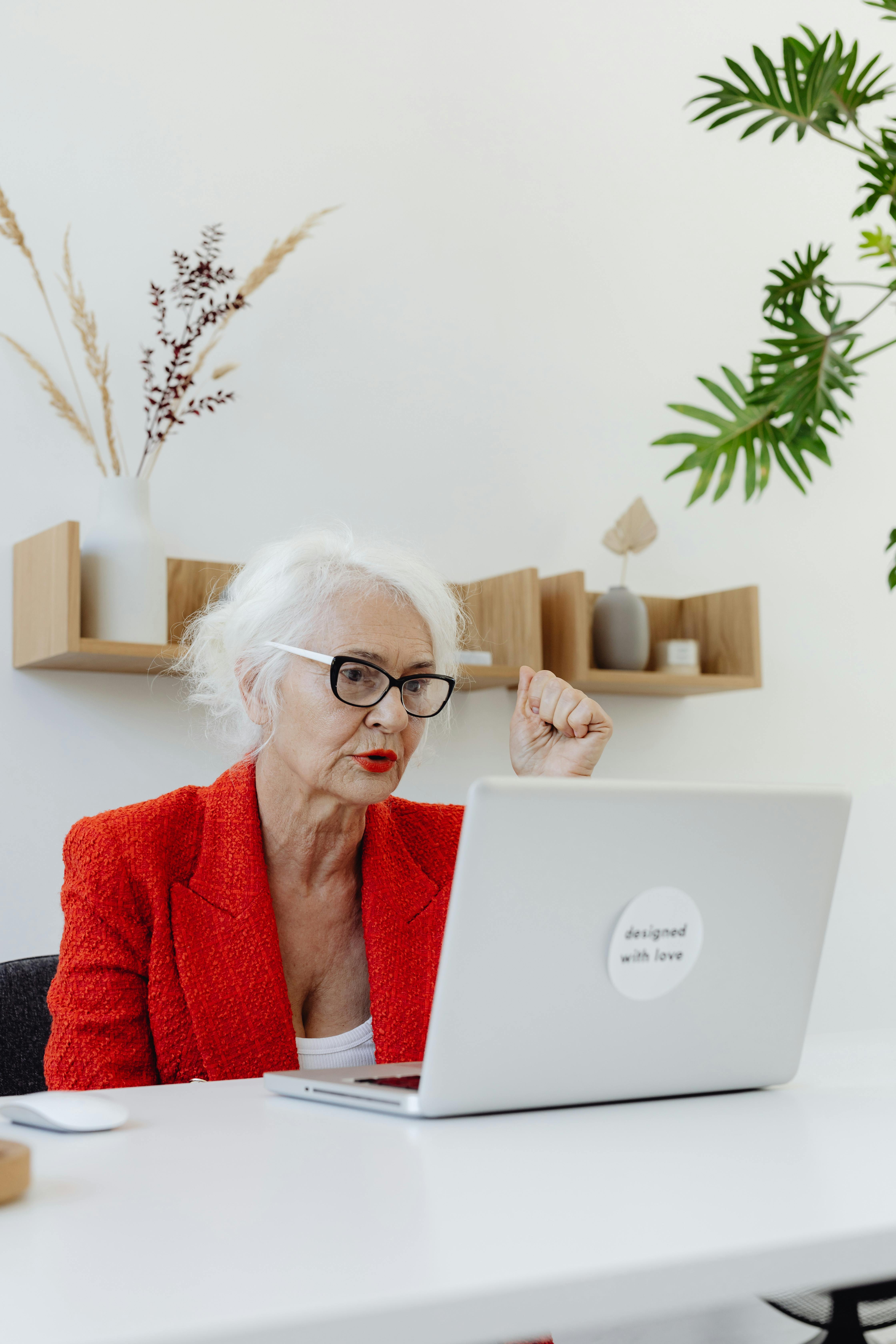 an elderly woman using laptop at work