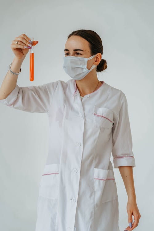 A Woman Holding a Test Tube with Colored Liquid