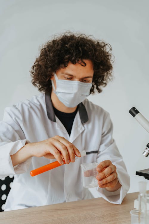 A Man Wearing Face Mask while Holding a Test Tube